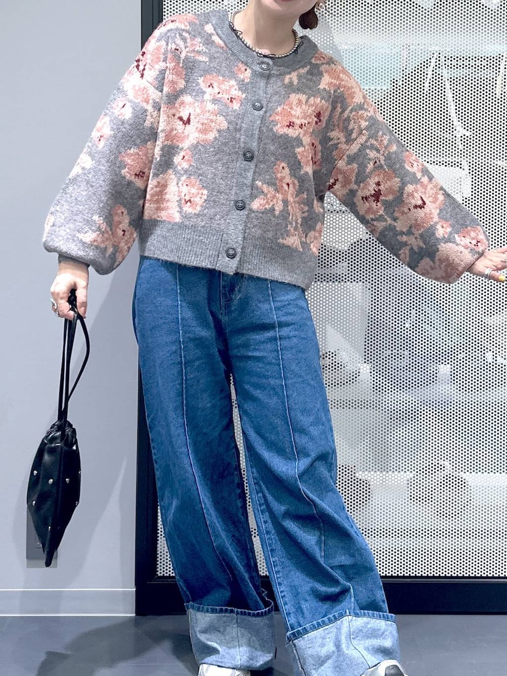 ブラック系のショルダーバッグ、ブルー系のデニムパンツ、グレー系のカーディガン/ボレロを着用したレディースの秋コーディネートの4枚目の写真