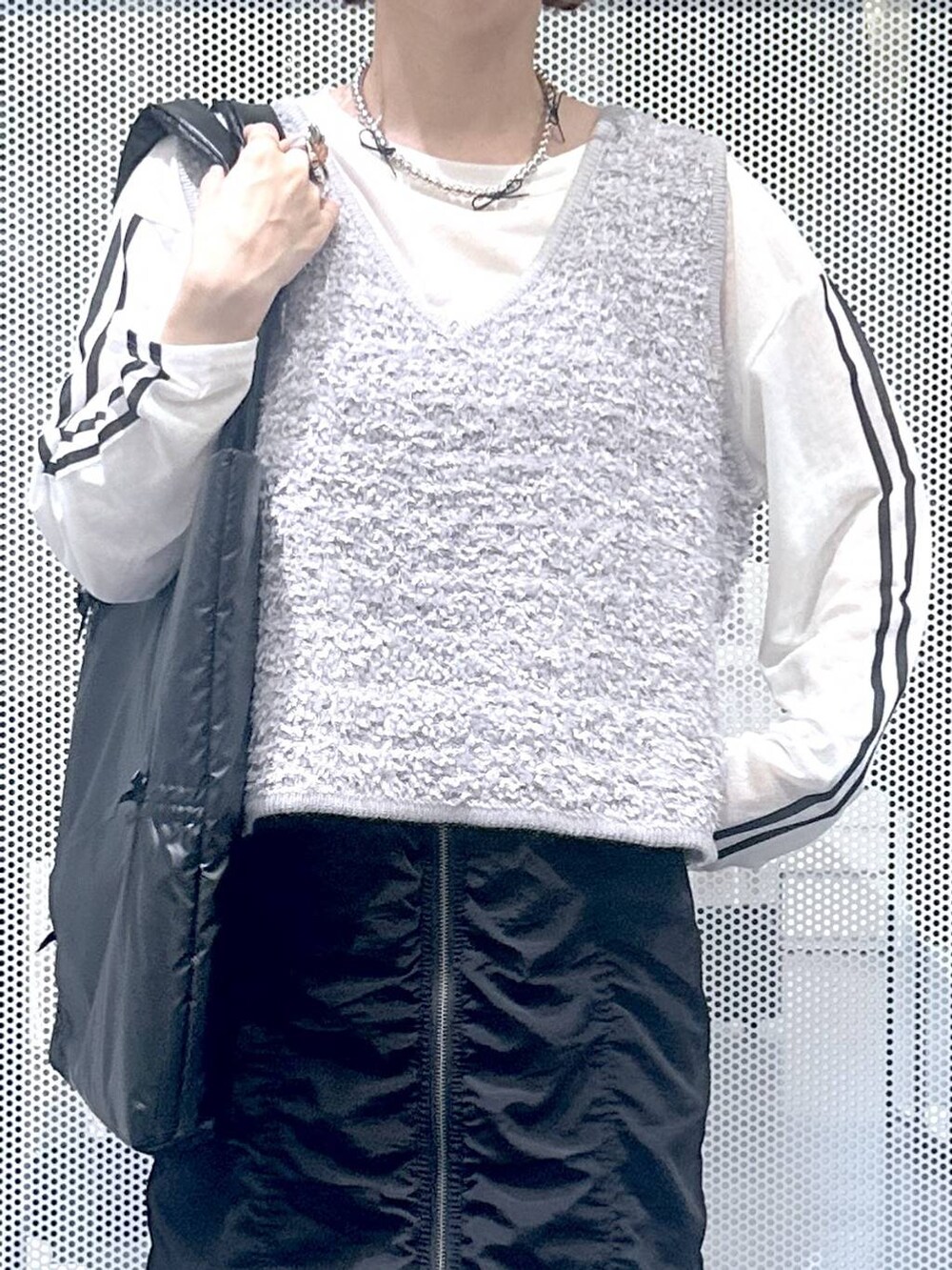グレー系のスニーカー、ホワイト系のTシャツ/カットソー、グレー系のベストを着用したレディースの秋コーディネートの5枚目の写真