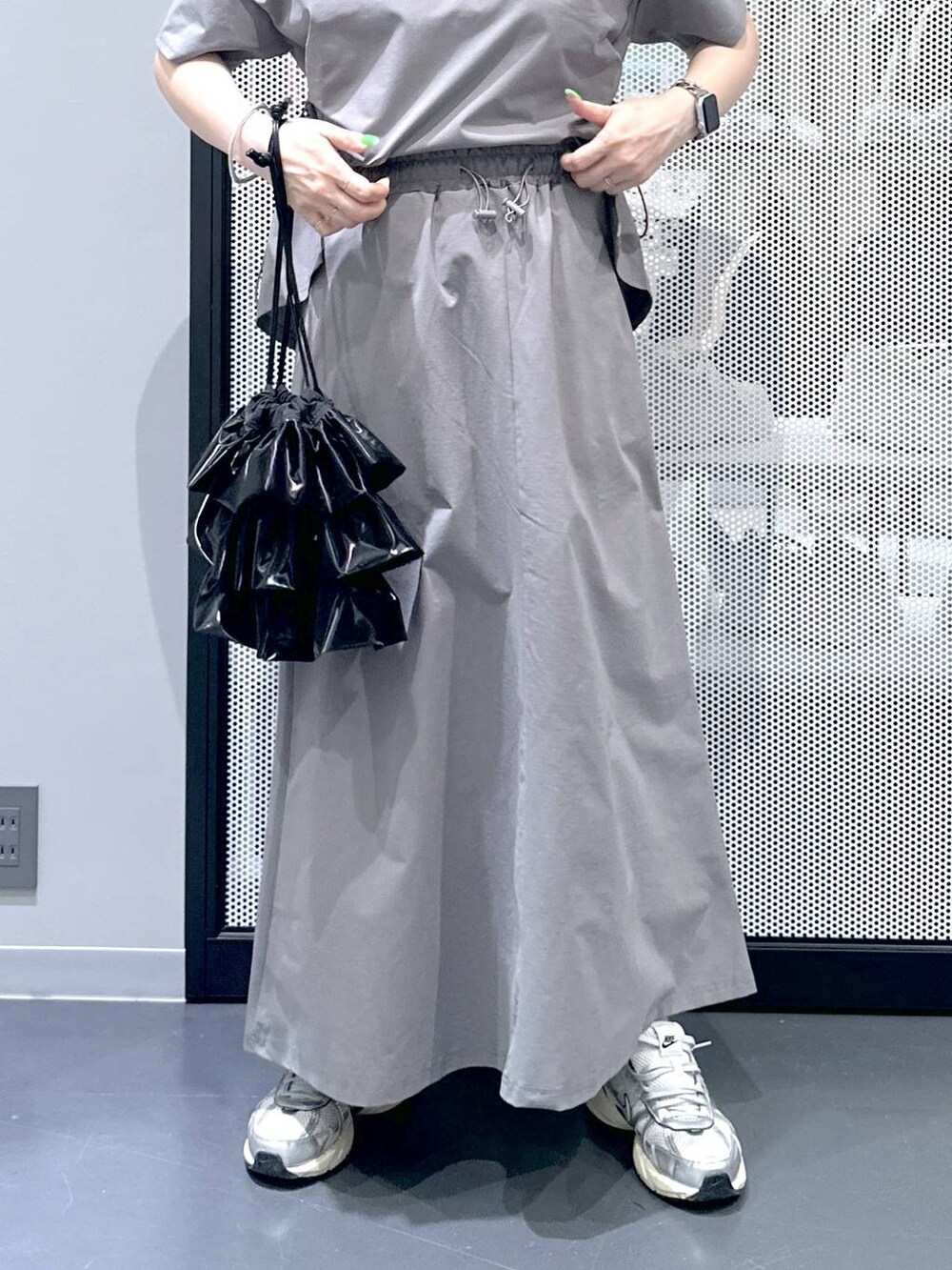 ブラック系のショルダーバッグ、グレー系のスカート、グレー系のTシャツ/カットソーを着用したレディースの春コーディネートの4枚目の写真