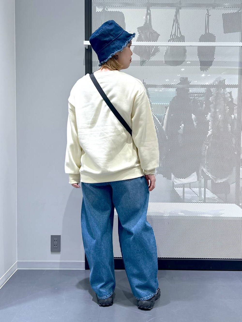 グレー系のスニーカー、ブルー系のデニムパンツ、グリーン系のミリタリージャケットを着用したレディースの冬コーディネートの4枚目の写真