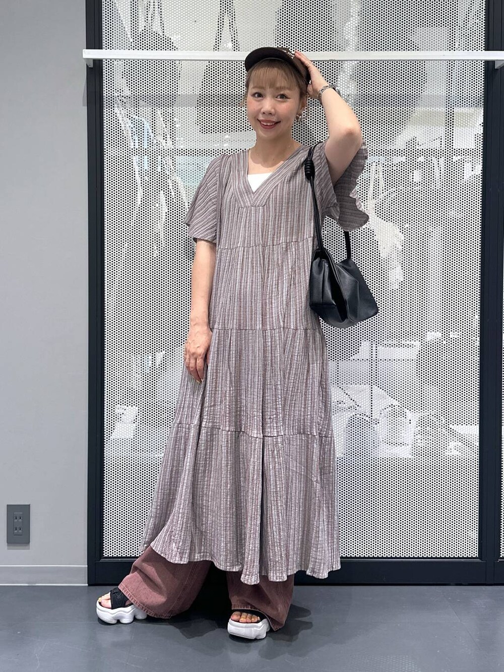 ホワイト系のキャミソール、グレー系のワンピース、ブラック系のショルダーバッグを着用したレディースの夏コーディネートの2枚目の写真