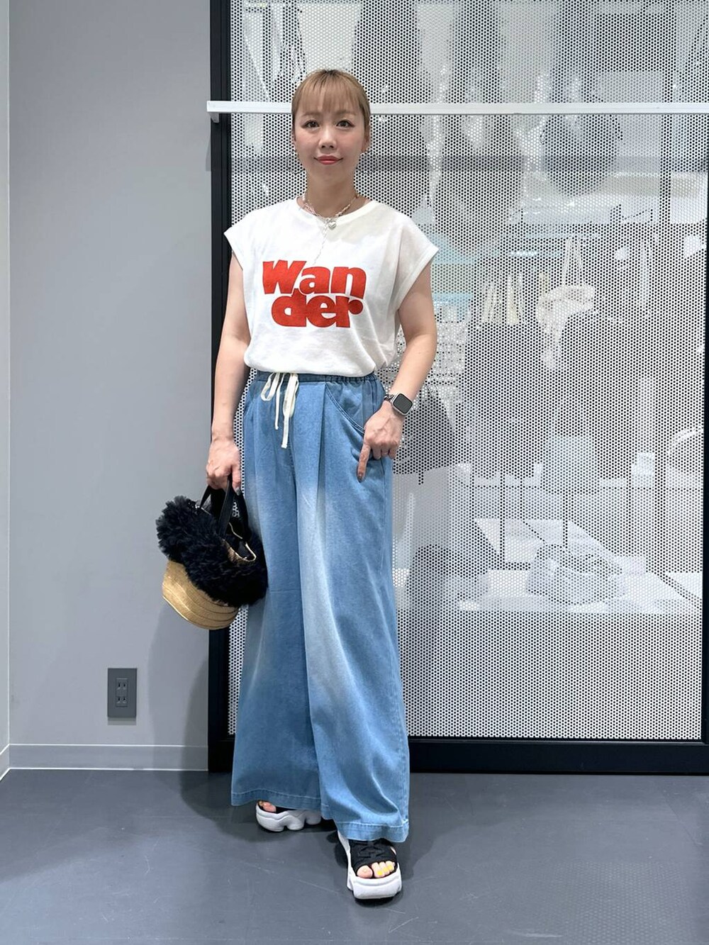 ベージュ系のショルダーバッグ、ブルー系のデニムパンツ、ホワイト系のTシャツ/カットソーを着用したレディースの夏コーディネートの2枚目の写真