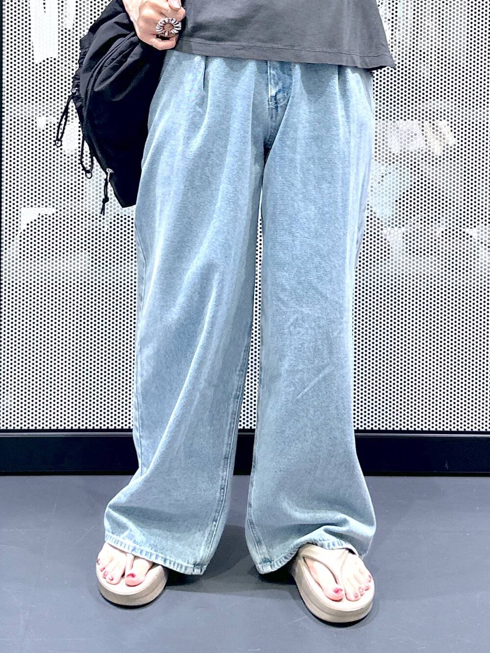 ブラック系のショルダーバッグ、ブルー系のデニムパンツ、ホワイト系のベストを着用したレディースの夏コーディネートの7枚目の写真