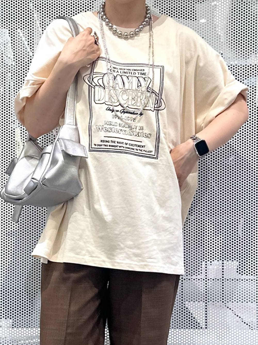 その他のショルダーバッグ、ブラウン系のその他パンツ、シルバー系のデジタル腕時計を着用したレディースの夏コーディネートの2枚目の写真