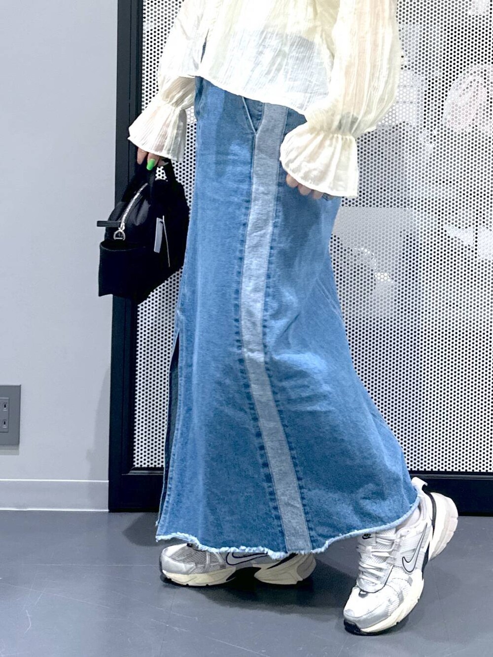 ブルー系のデニムスカート、ベージュ系のシャツ/ブラウス、ブラック系のショルダーバッグを着用したレディースの春コーディネートの5枚目の写真