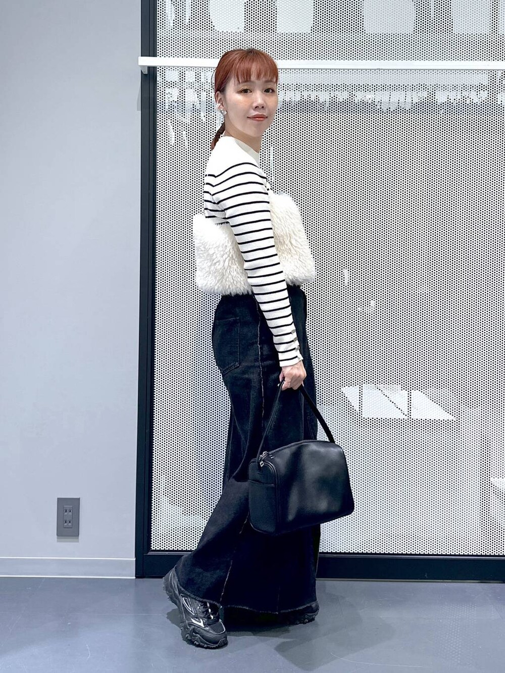 ホワイト系のニット/セーター、グレー系のスニーカー、ブラック系のショルダーバッグを着用したレディースの秋コーディネートの2枚目の写真