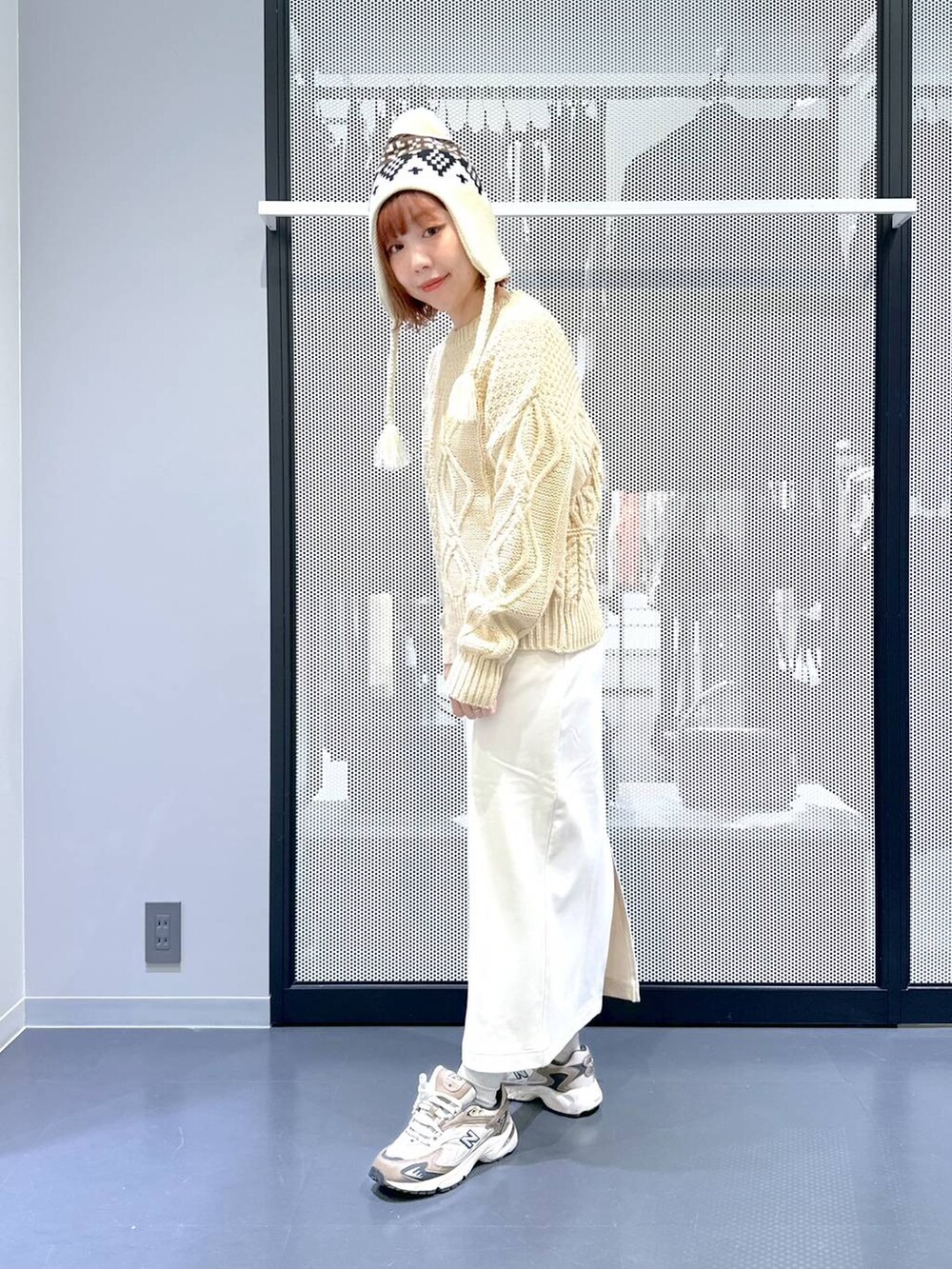 ブラウン系のスニーカー、ベージュ系のショルダーバッグ、グリーン系のナイロンジャケットを着用したレディースの冬コーディネートの3枚目の写真