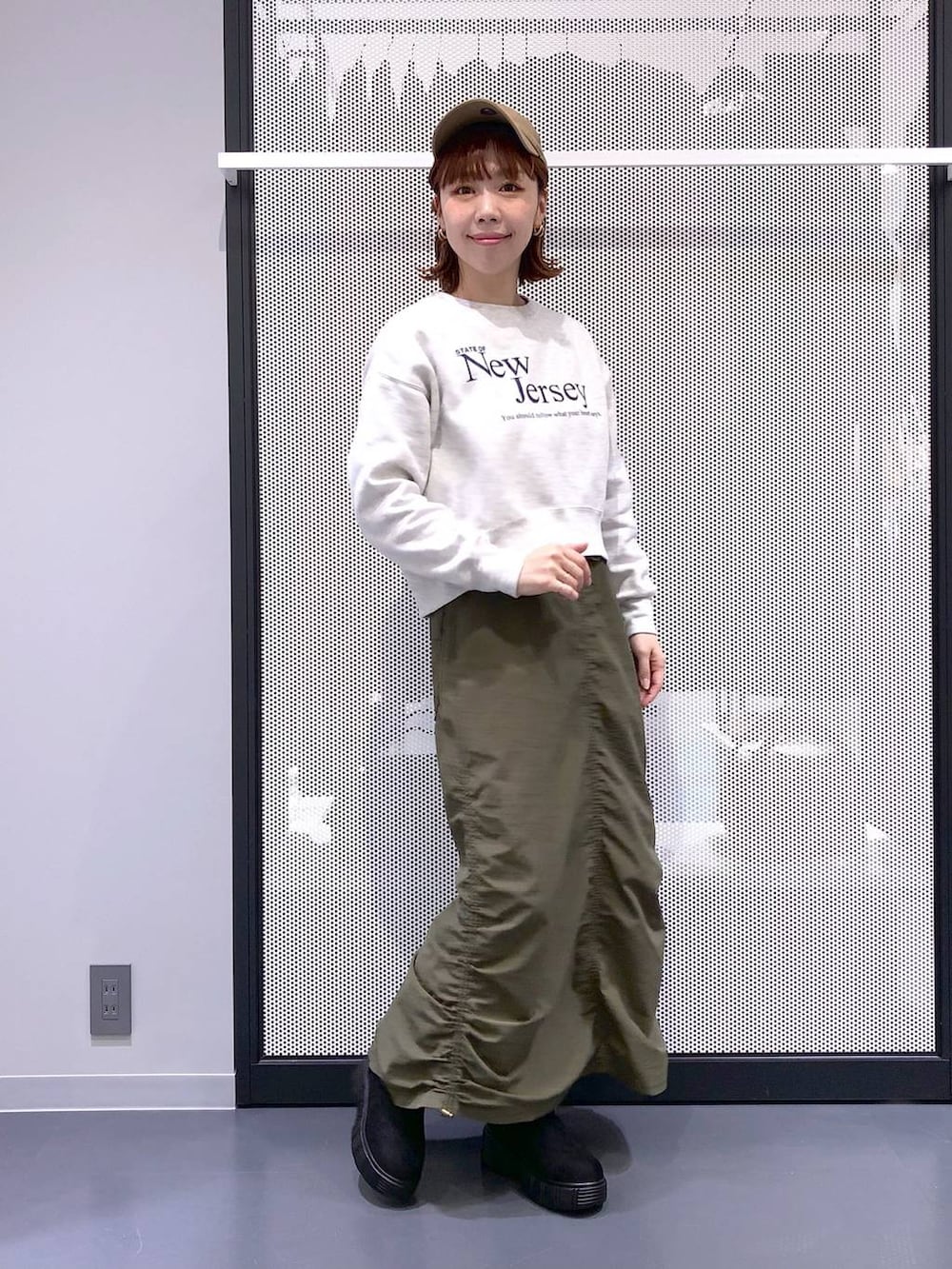 ブラック系のバックパック/リュック、グリーン系のスカート、ブラック系のベストを着用したレディースの冬コーディネートの2枚目の写真