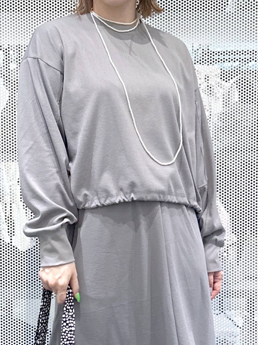 グレー系のスカート、グレー系のTシャツ/カットソー、ブラック系のトートバッグを着用したレディースの春コーディネートの4枚目の写真