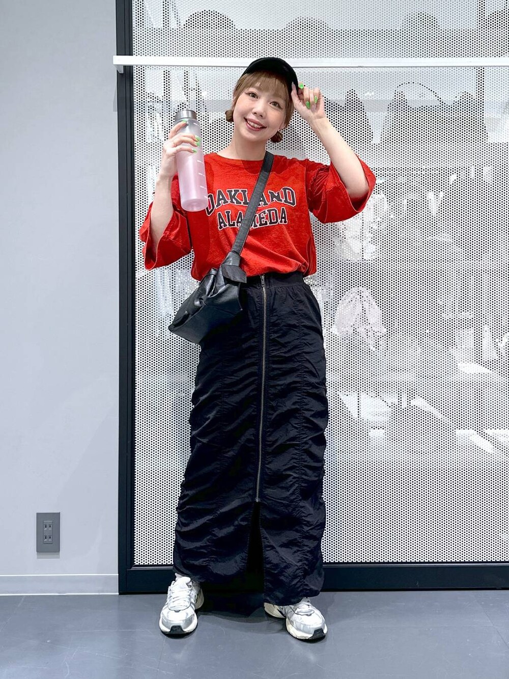 ブラック系のスカート、ブラック系のショルダーバッグ、レッド系のTシャツ/カットソーを着用したレディースの春コーディネートの2枚目の写真