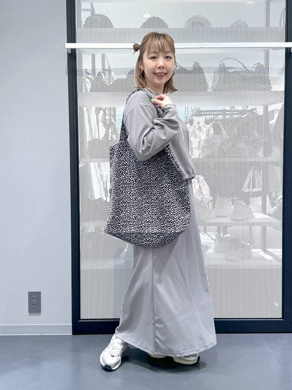 グレー系のスカート、グレー系のTシャツ/カットソー、ブラック系のトートバッグを着用したレディースの春コーディネートの2枚目の写真