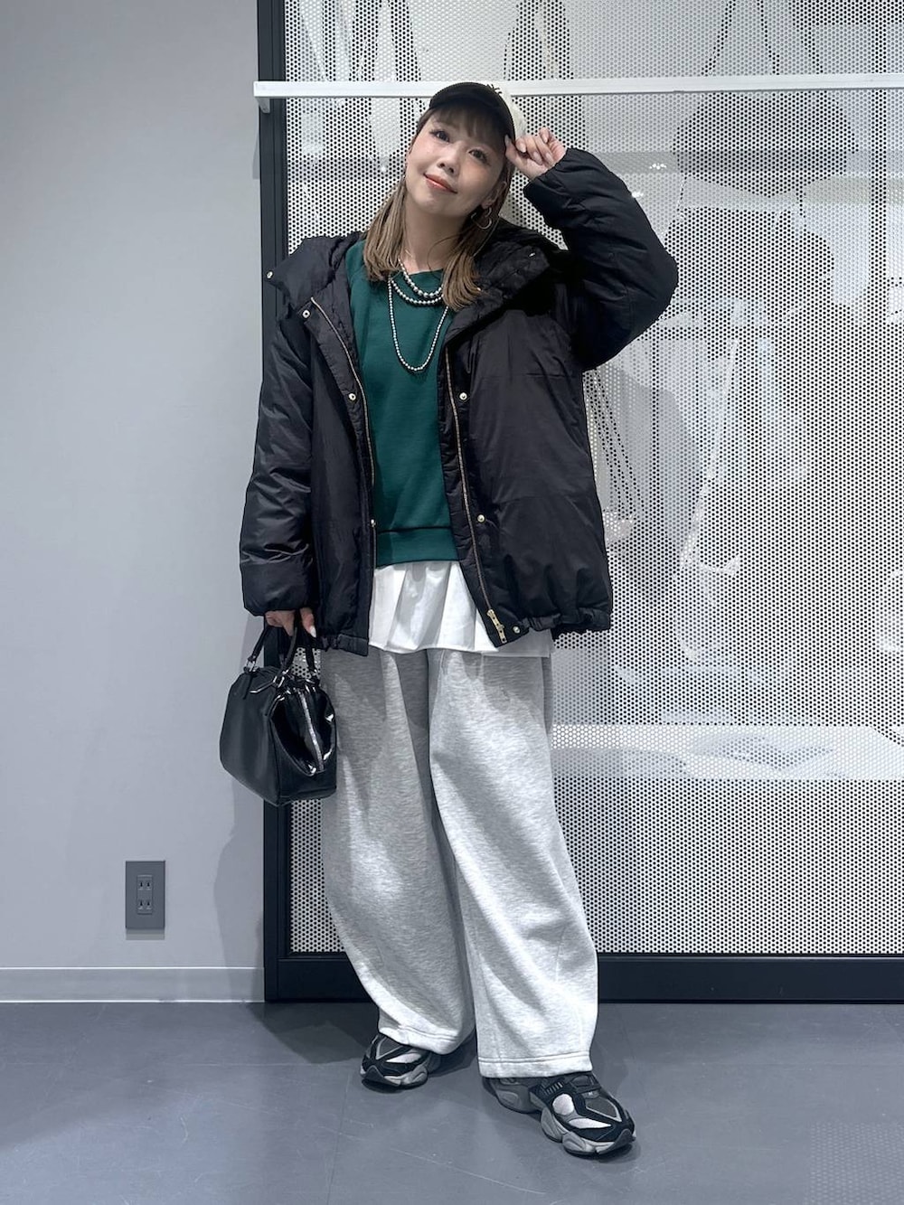 ブラック系のダウンジャケット/コート、ブラック系のショルダーバッグ、グレー系のスウェットパンツを着用したレディースの冬コーディネートの3枚目の写真