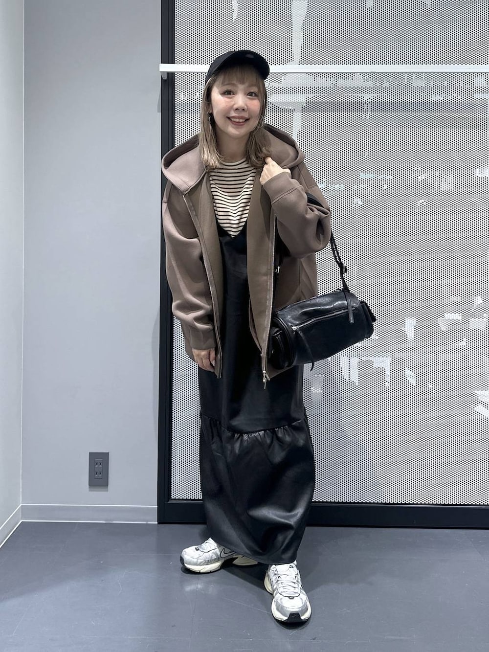 ブラウン系のパーカー、その他のピアス(両耳用)、ブルー系のキャップを着用したレディースの秋コーディネートの2枚目の写真