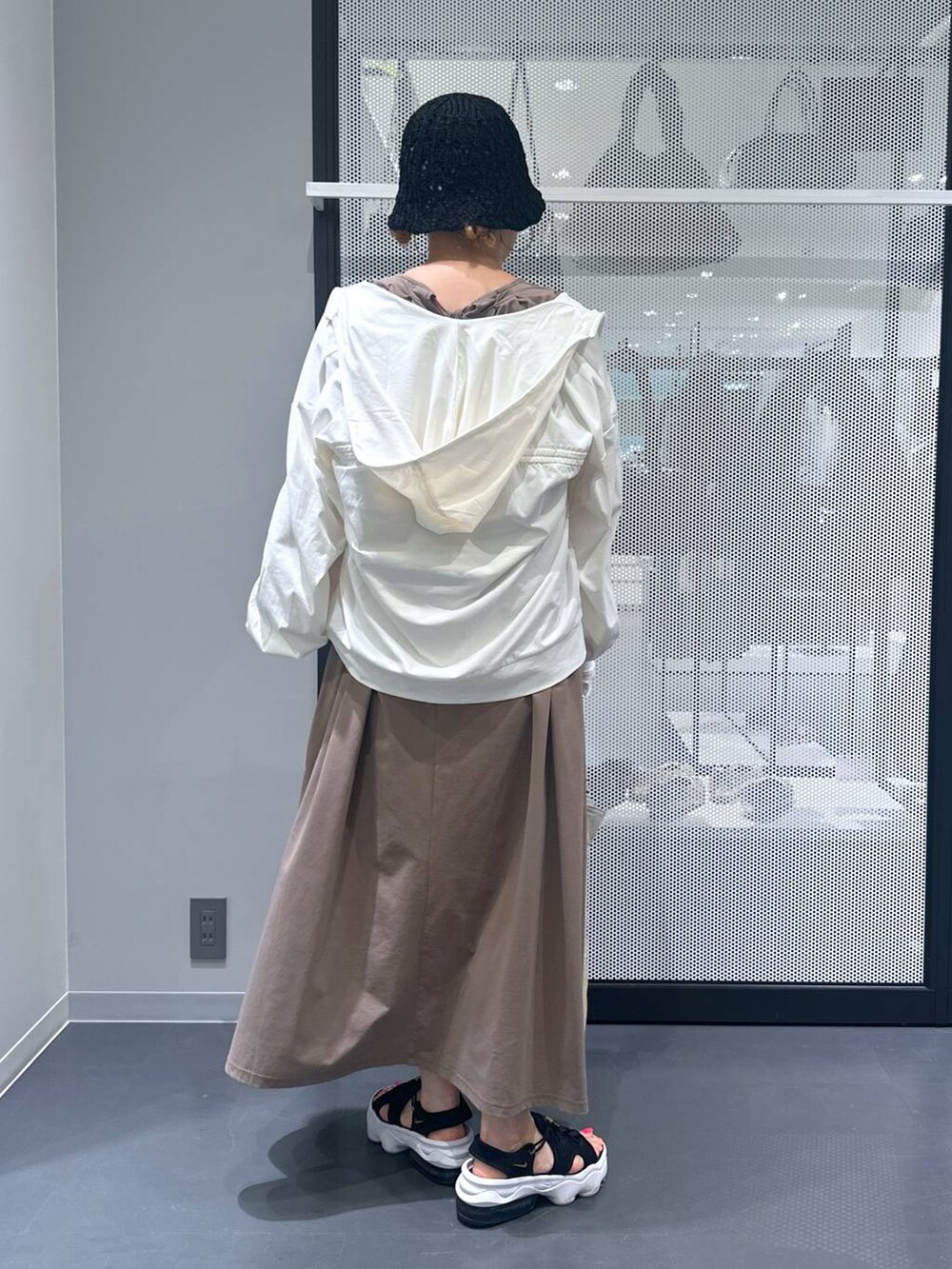 ブラウン系のワンピース、ブラック系のサンダル、ベージュ系の長傘を着用したレディースの春コーディネートの3枚目の写真