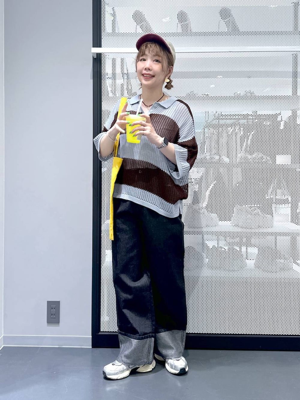 ブラック系のデニムパンツ、イエロー系のトートバッグ、ブルー系のニット/セーターを着用したレディースの春コーディネートの6枚目の写真