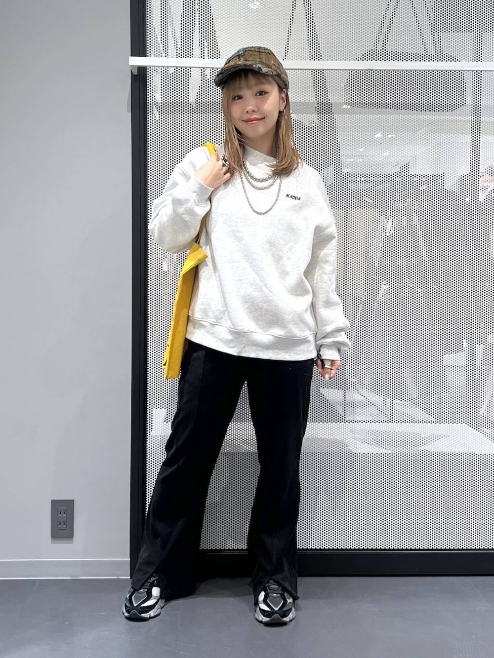 イエロー系のトートバッグ、ブラック系のダウンジャケット/コート、ブラック系のその他パンツを着用したレディースの冬コーディネートの9枚目の写真