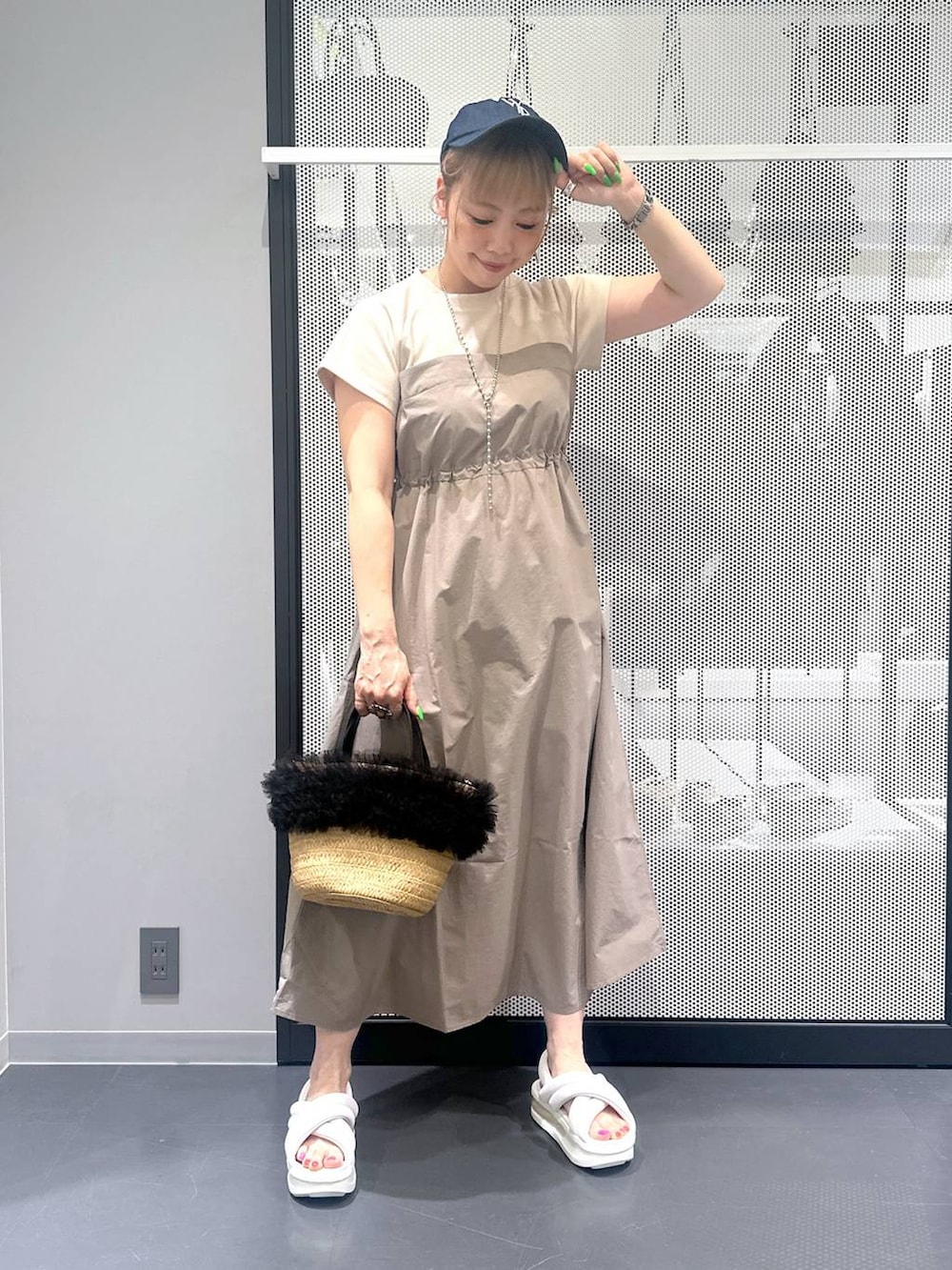 ベージュ系のショルダーバッグ、ベージュ系のワンピース、ホワイト系のサンダルを着用したレディースの春コーディネートの2枚目の写真