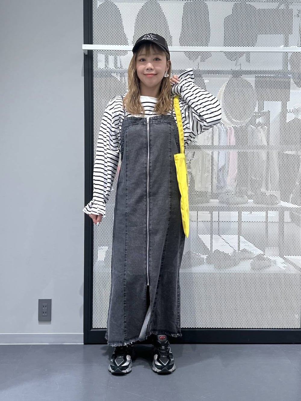 イエロー系のトートバッグ、その他のピアス（両耳用）を着用したレディースの春コーディネートの2枚目の写真