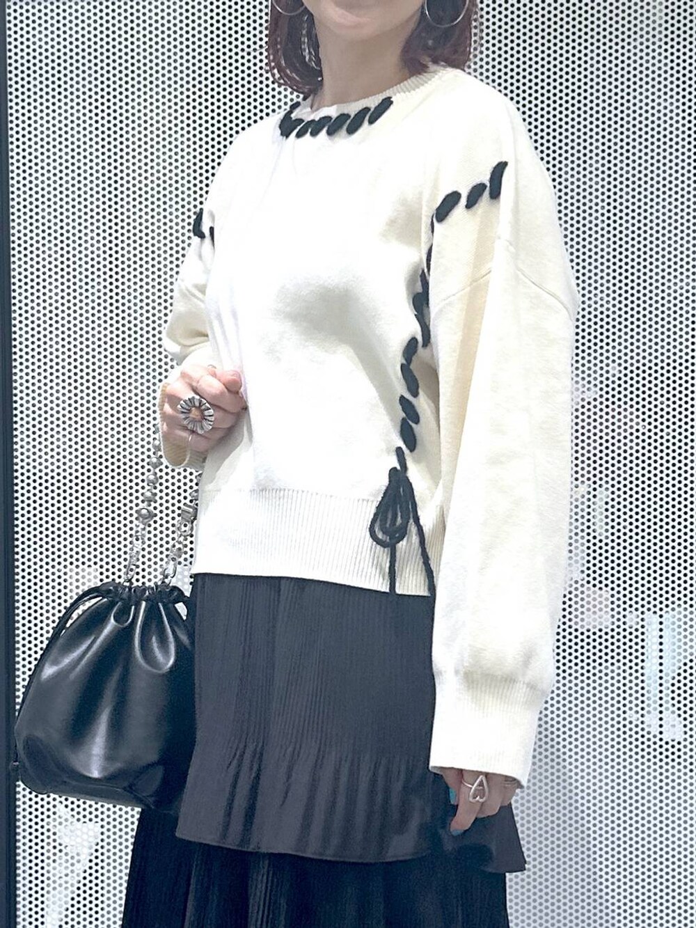 ブラック系のスカート、ブラック系のショルダーバッグ、シルバー系のパンプスを着用したレディースの秋コーディネートの4枚目の写真