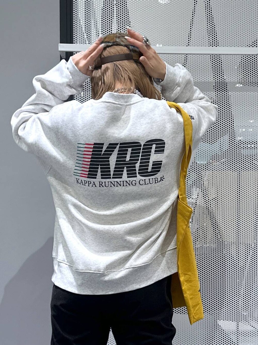 イエロー系のトートバッグ、ブラック系のダウンジャケット/コート、ブラック系のその他パンツを着用したレディースの冬コーディネートの6枚目の写真