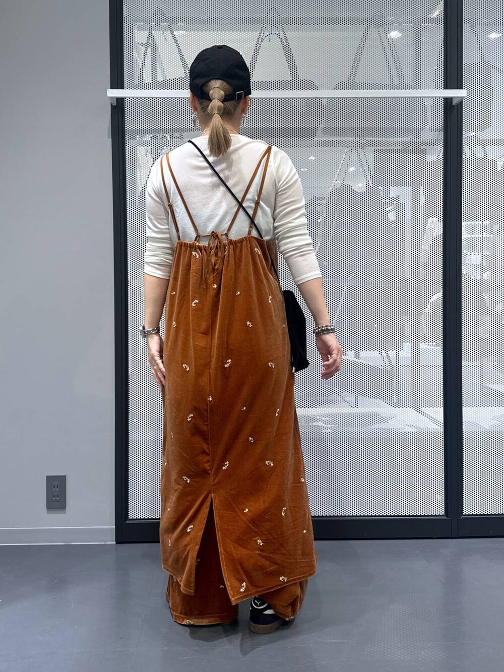 ホワイト系のTシャツ/カットソー、ブラック系のスニーカー、ブラック系のショルダーバッグを着用したレディースの秋コーディネートの3枚目の写真