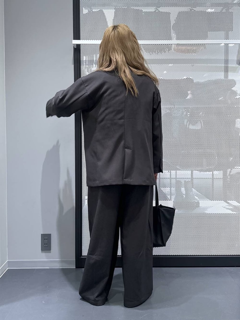 ブラック系のトートバッグ、グレー系のスラックス、ブラック系のローファーを着用したレディースの春コーディネートの3枚目の写真