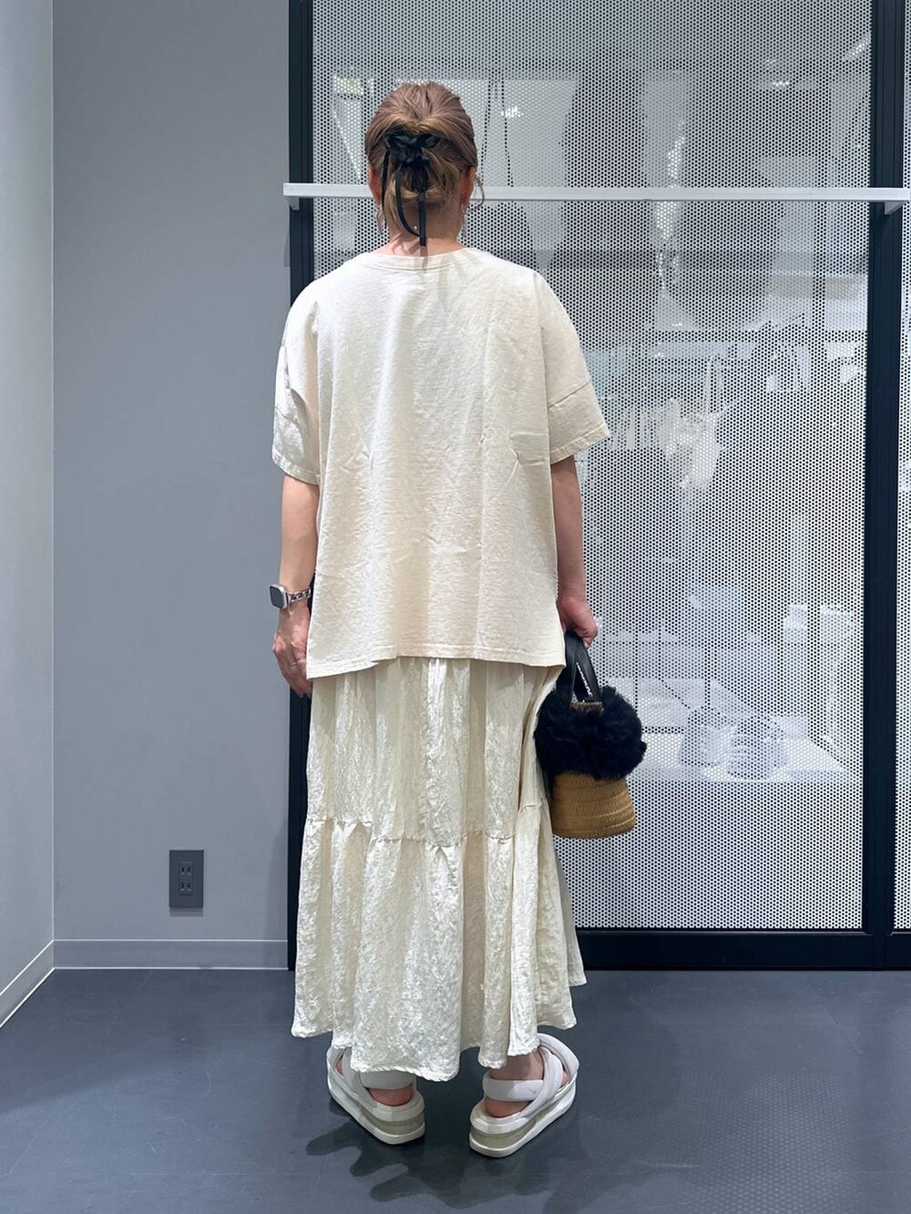 ベージュ系のショルダーバッグ、ホワイト系のスカート、ブラック系のバレッタ/ヘアクリップを着用したレディースの夏コーディネートの3枚目の写真