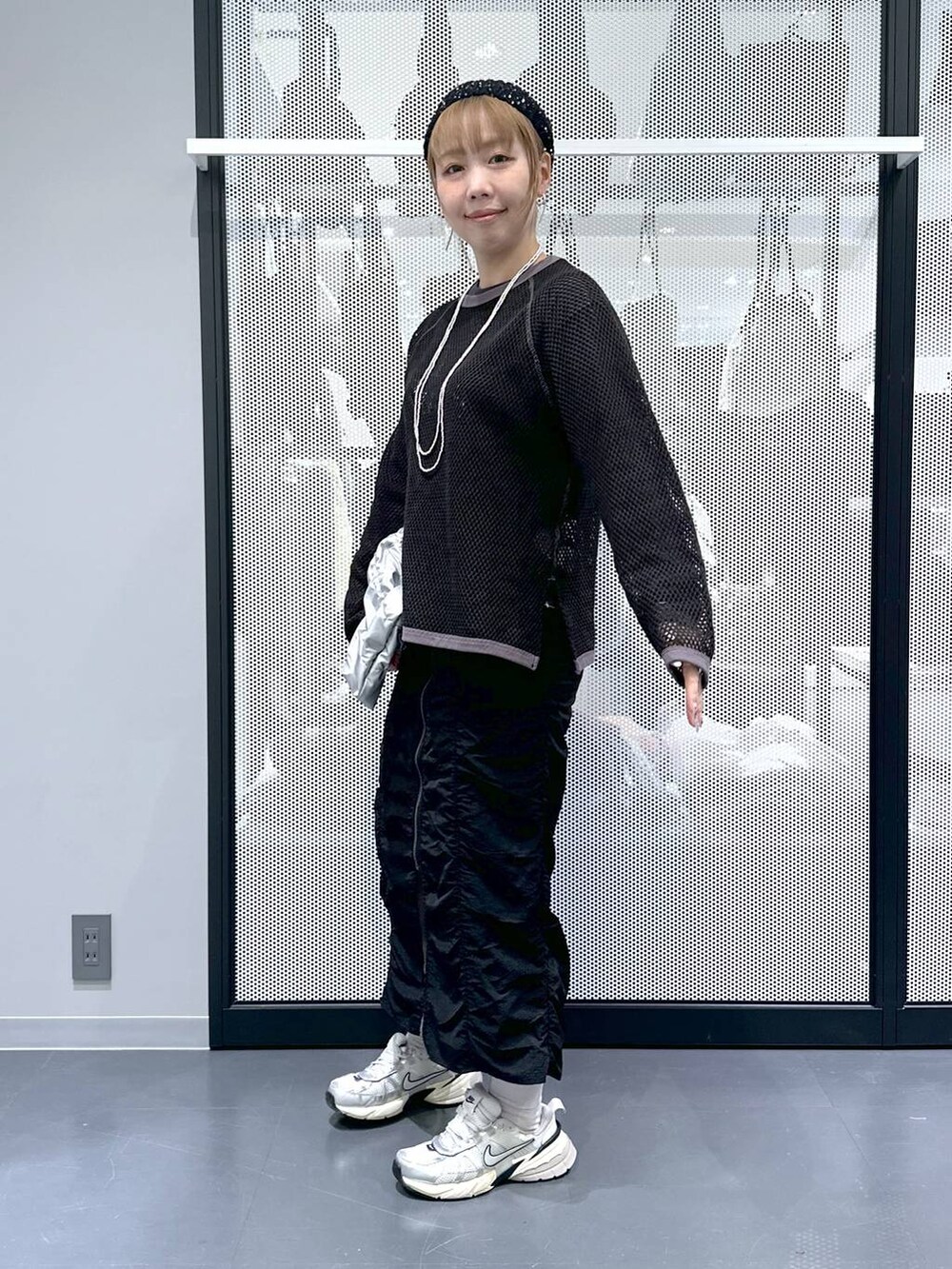 ブラック系のスカート、シルバー系のショルダーバッグ、グレー系のTシャツ/カットソーを着用したレディースの春コーディネートの6枚目の写真