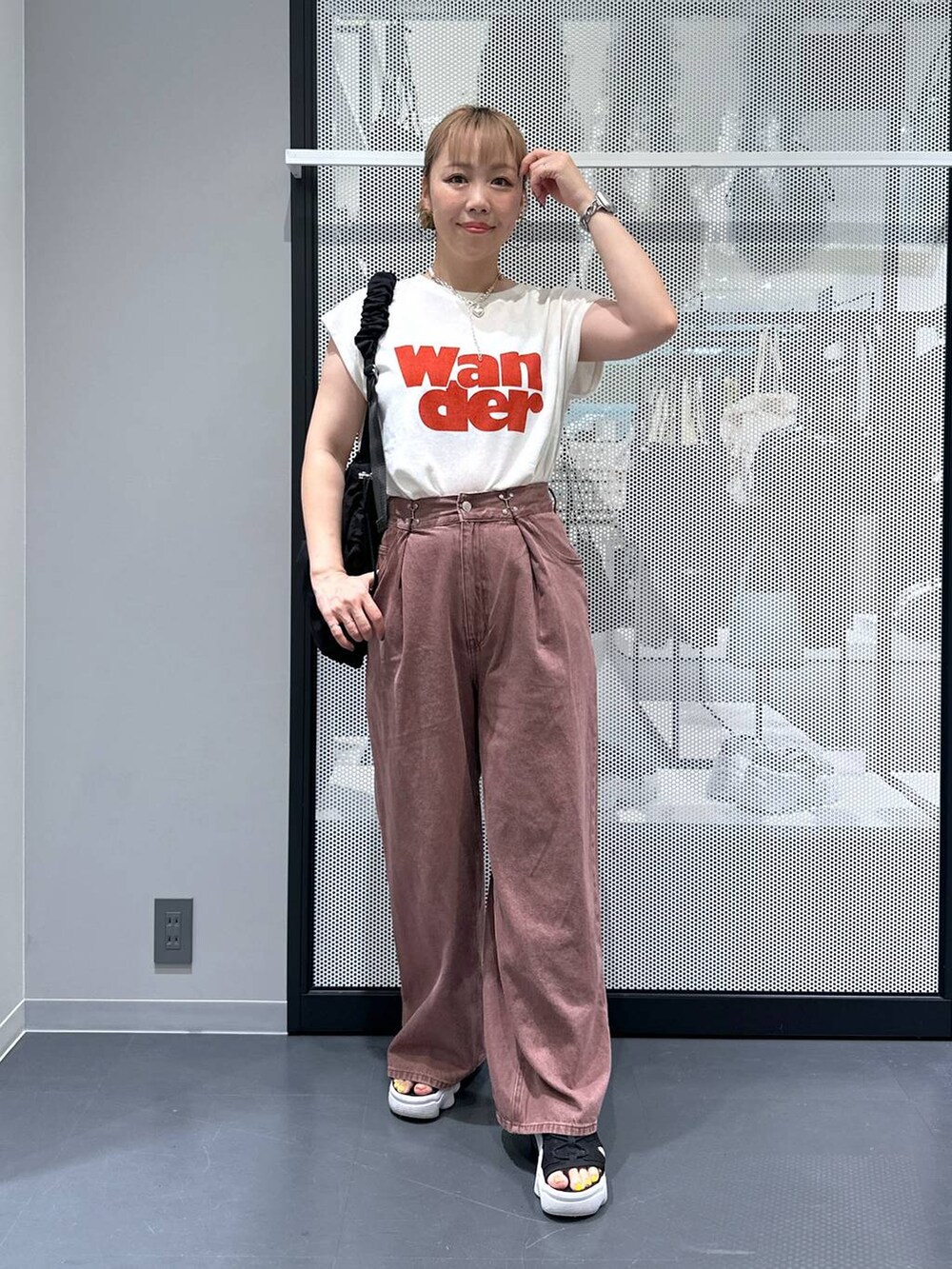 ブラック系のショルダーバッグ、ホワイト系のTシャツ/カットソー、ブラウン系のデニムパンツを着用したレディースの夏コーディネートの6枚目の写真