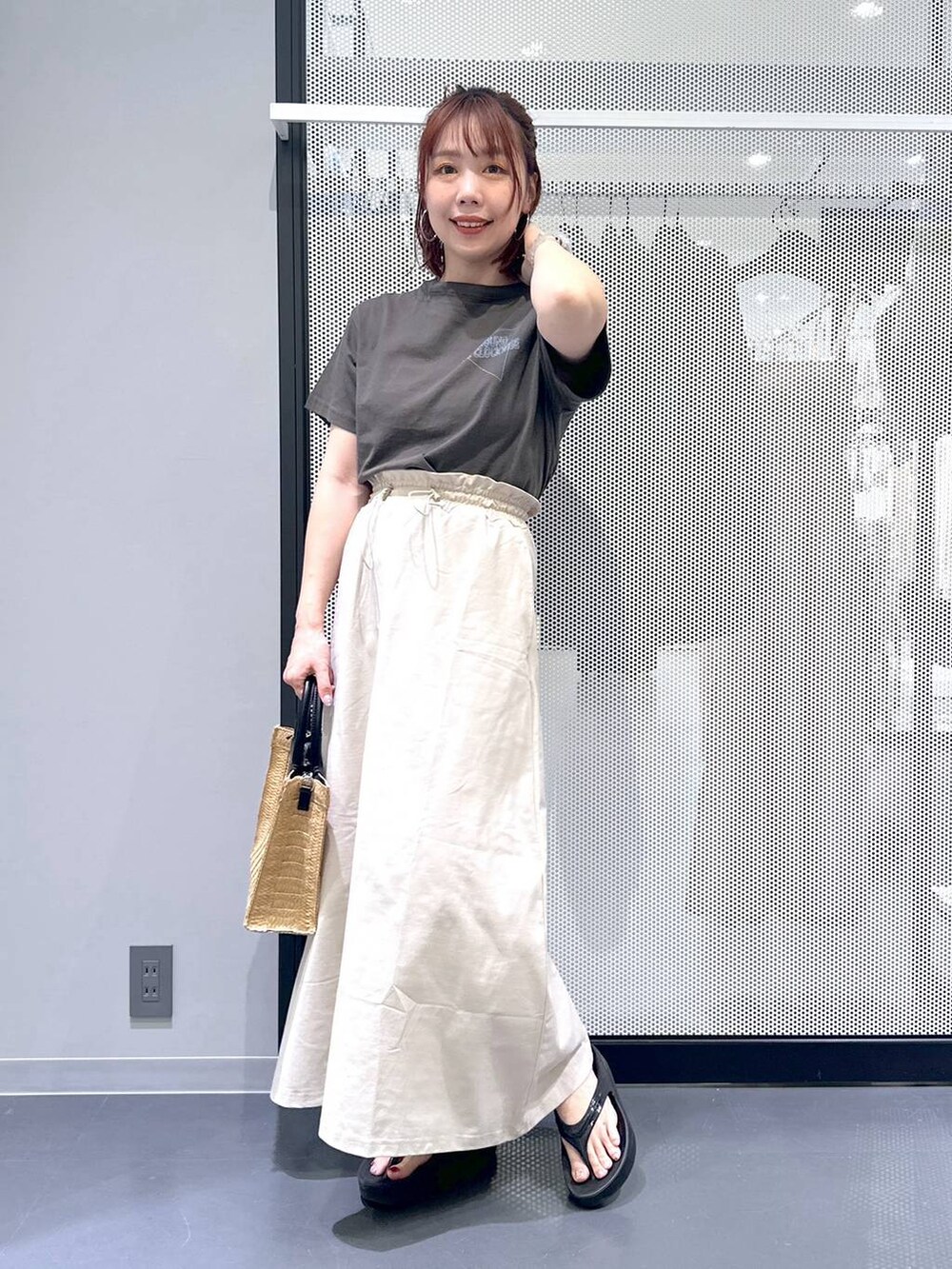 ベージュ系のスカート、ブラック系のサンダル、ベージュ系のショルダーバッグを着用したレディースの夏コーディネートの4枚目の写真