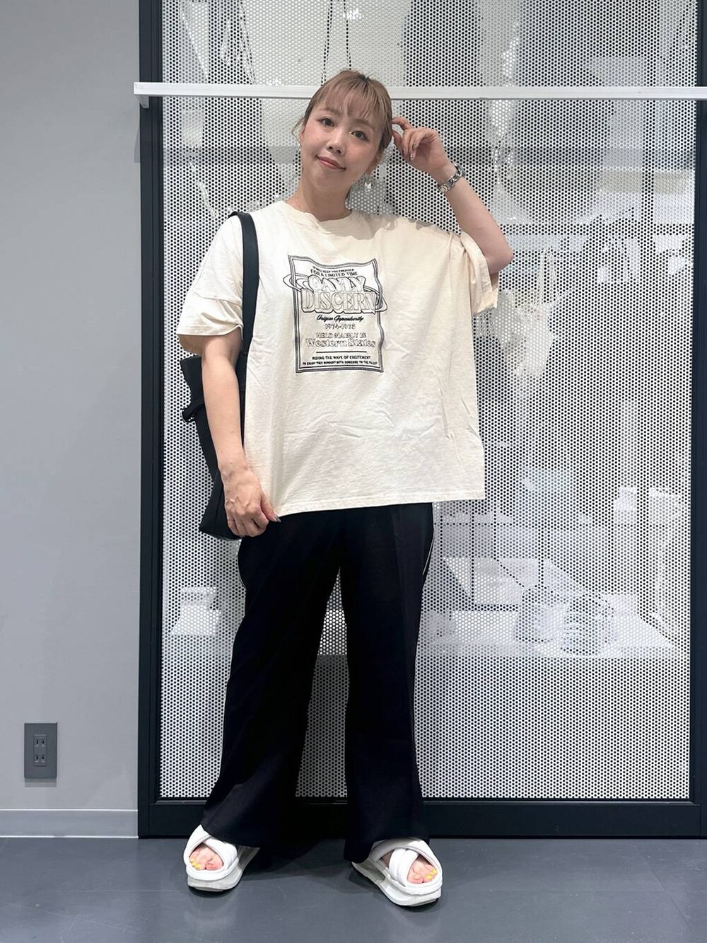 ブラック系のスラックス、ブラック系のショルダーバッグ、ブラック系のバレッタ/ヘアクリップを着用したレディースの夏コーディネートの2枚目の写真