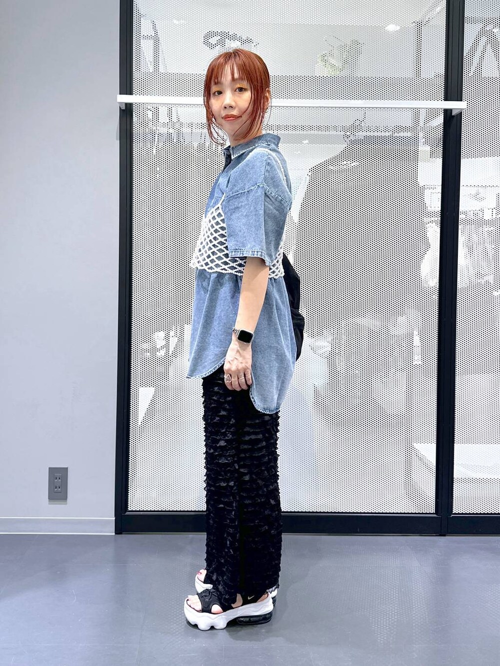 ブラック系のショルダーバッグ、ホワイト系のベスト、ブルー系のシャツ/ブラウスを着用したレディースの夏コーディネートの2枚目の写真