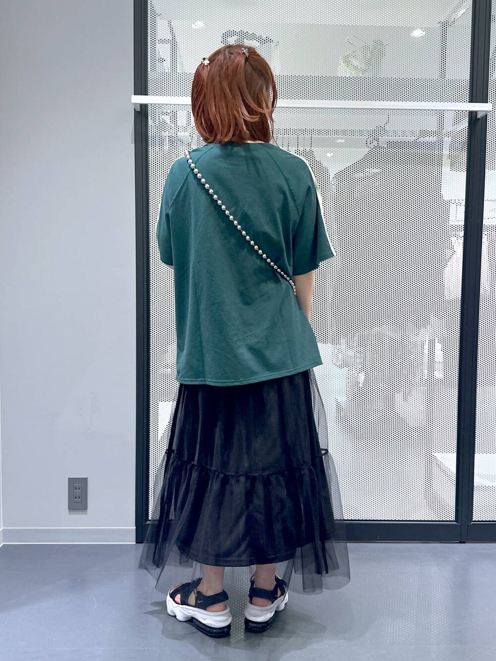 ブラック系のスカート、グリーン系のTシャツ/カットソー、その他のネックレスを着用したレディースの夏コーディネートの3枚目の写真