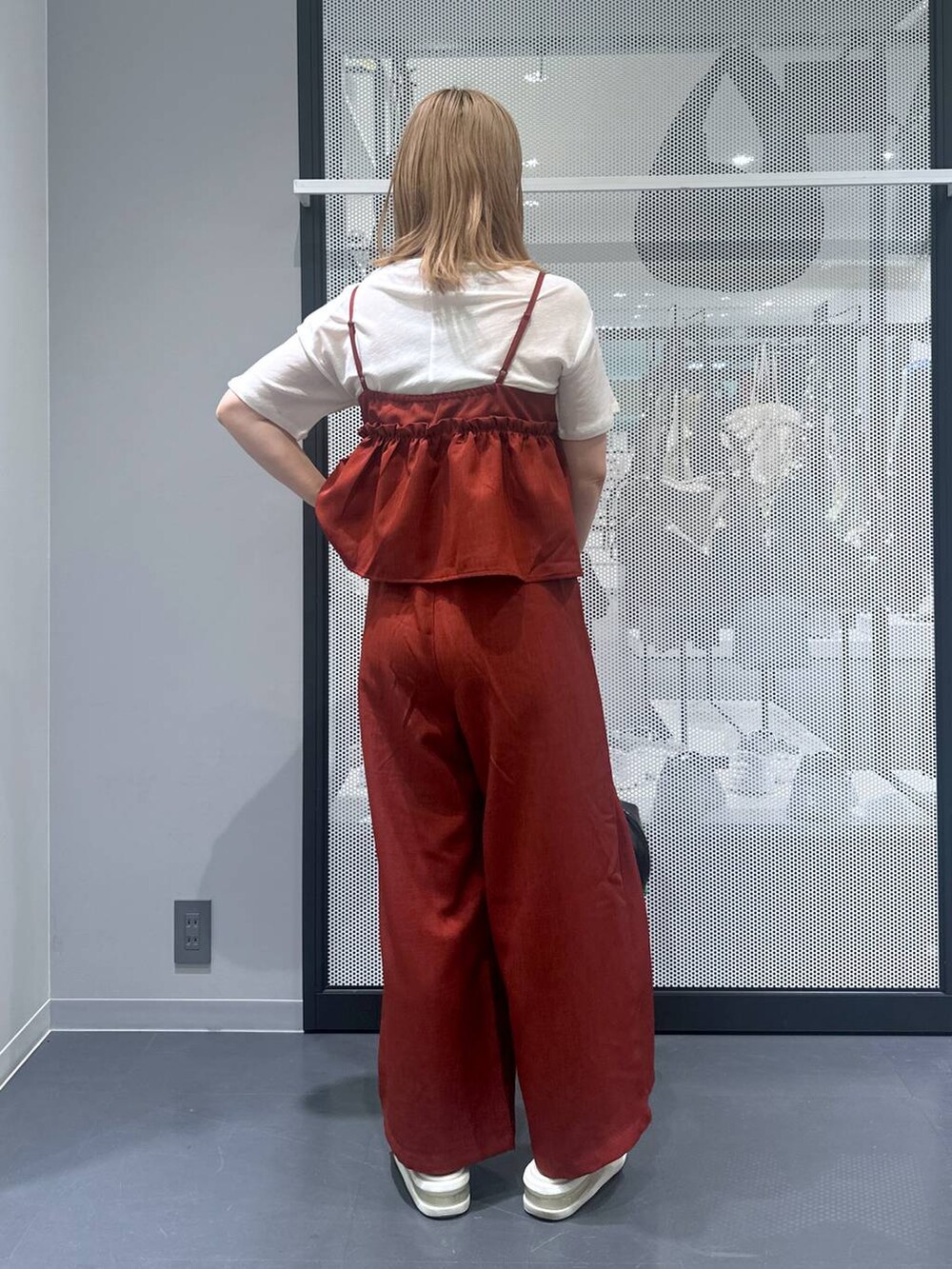 ブラック系のボストンバッグ、ホワイト系のTシャツ/カットソー、レッド系のつなぎ/オールインワンを着用したレディースの夏コーディネートの3枚目の写真