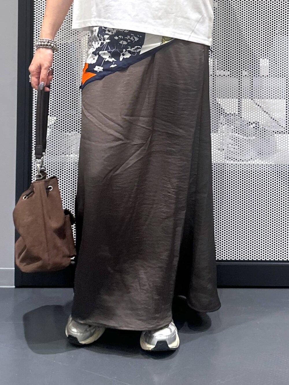 ブラウン系のショルダーバッグ、グレー系のスカート、その他のピアス（両耳用）を着用したレディースの夏コーディネートの4枚目の写真