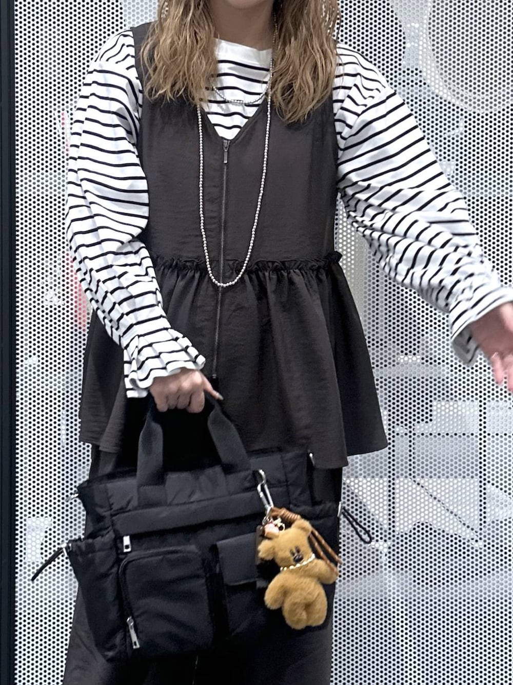 グレー系のその他パンツ、ブラック系のトートバッグ、ベージュ系のスニーカーを着用したレディースの春コーディネートの4枚目の写真