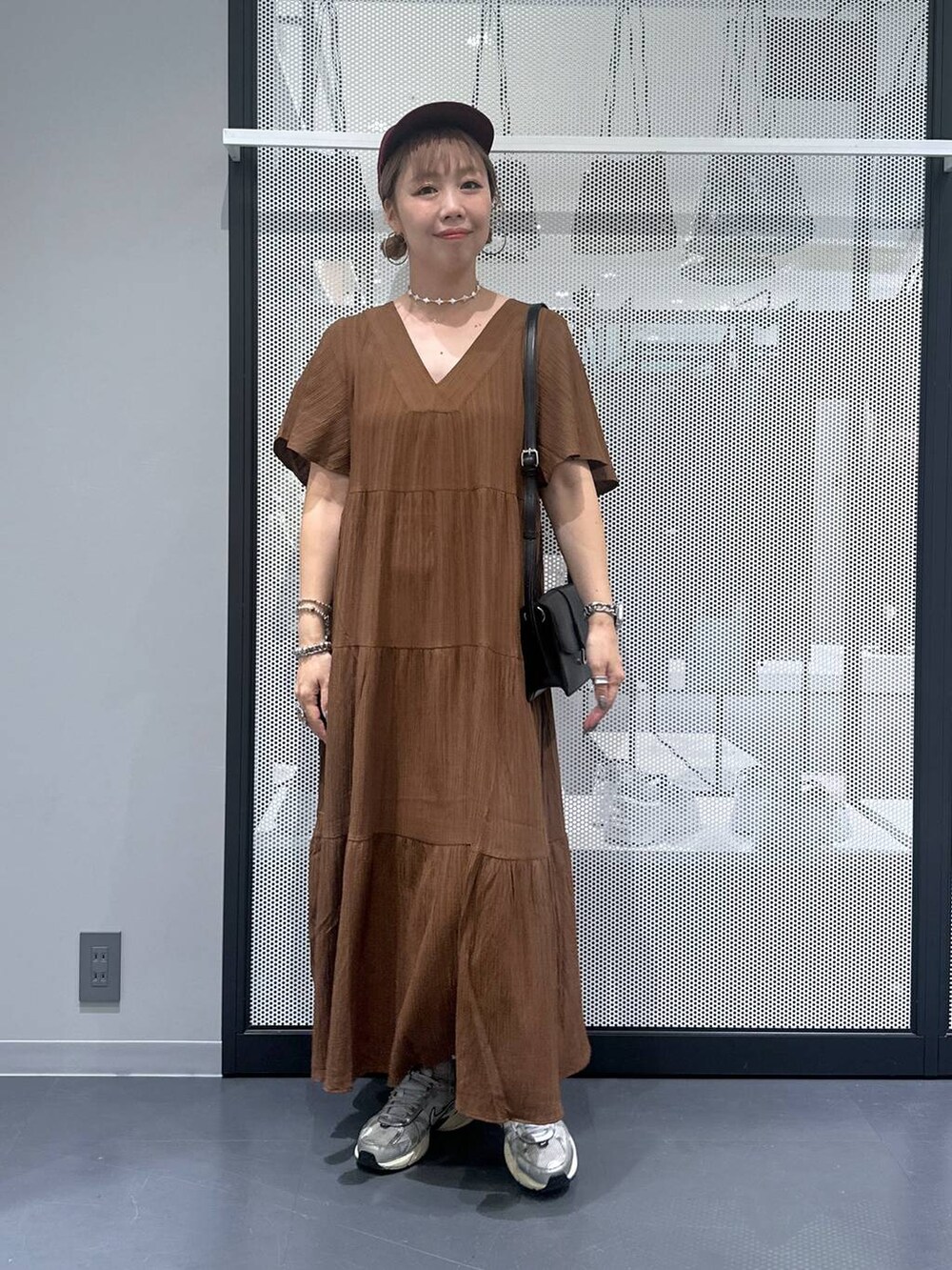 ブラック系のショルダーバッグ、その他のピアス（両耳用）、シルバー系のデジタル腕時計を着用したレディースの夏コーディネートの5枚目の写真