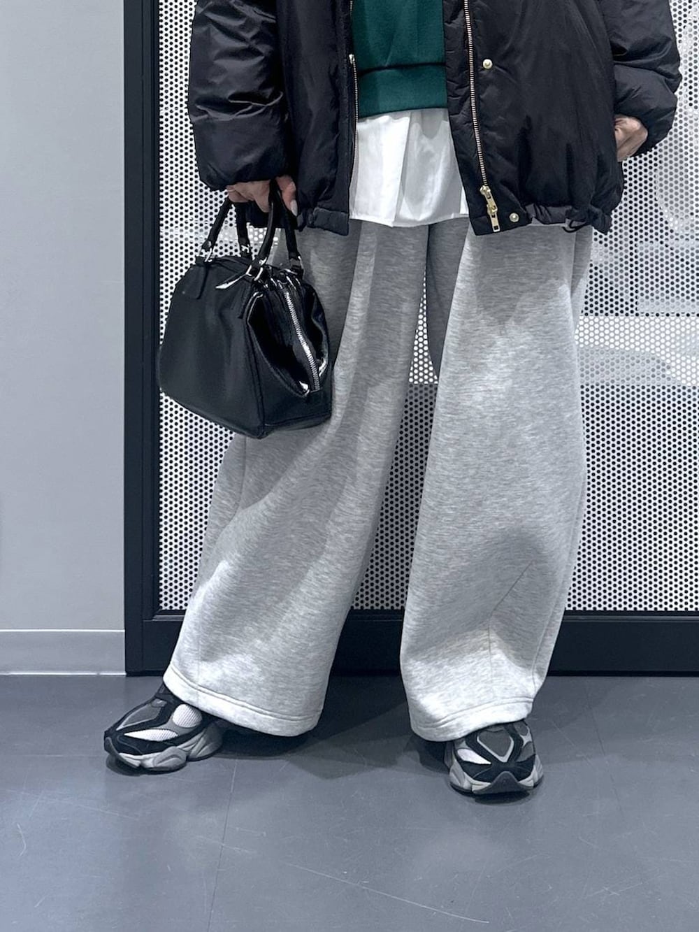 ブラック系のダウンジャケット/コート、ブラック系のショルダーバッグ、グレー系のスウェットパンツを着用したレディースの冬コーディネートの5枚目の写真