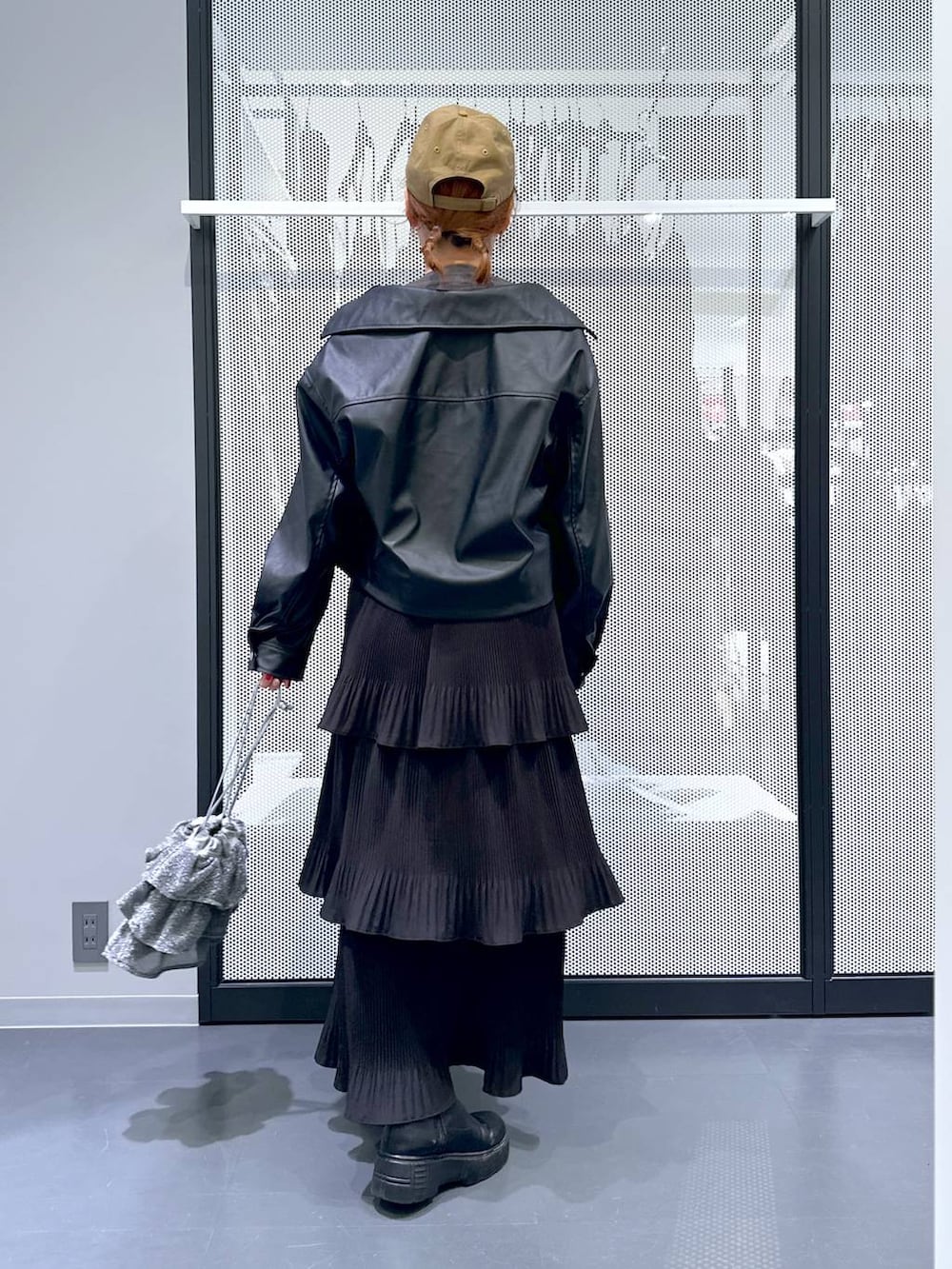 グレー系のデニムジャケット、シルバー系のショルダーバッグ、ブラック系のスカートを着用したレディースの春コーディネートの3枚目の写真