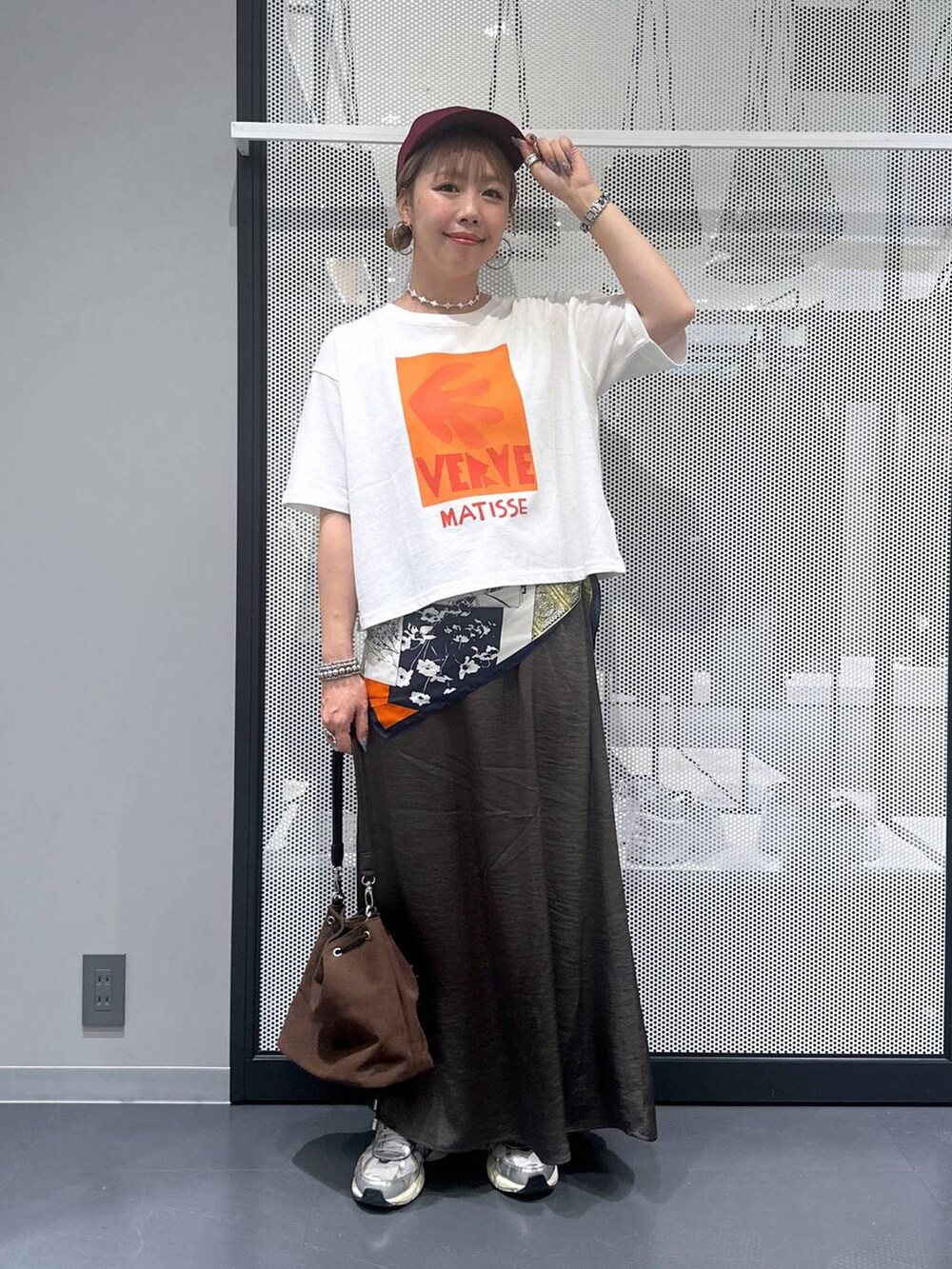 ブラウン系のショルダーバッグ、グレー系のスカート、その他のピアス（両耳用）を着用したレディースの夏コーディネートの5枚目の写真