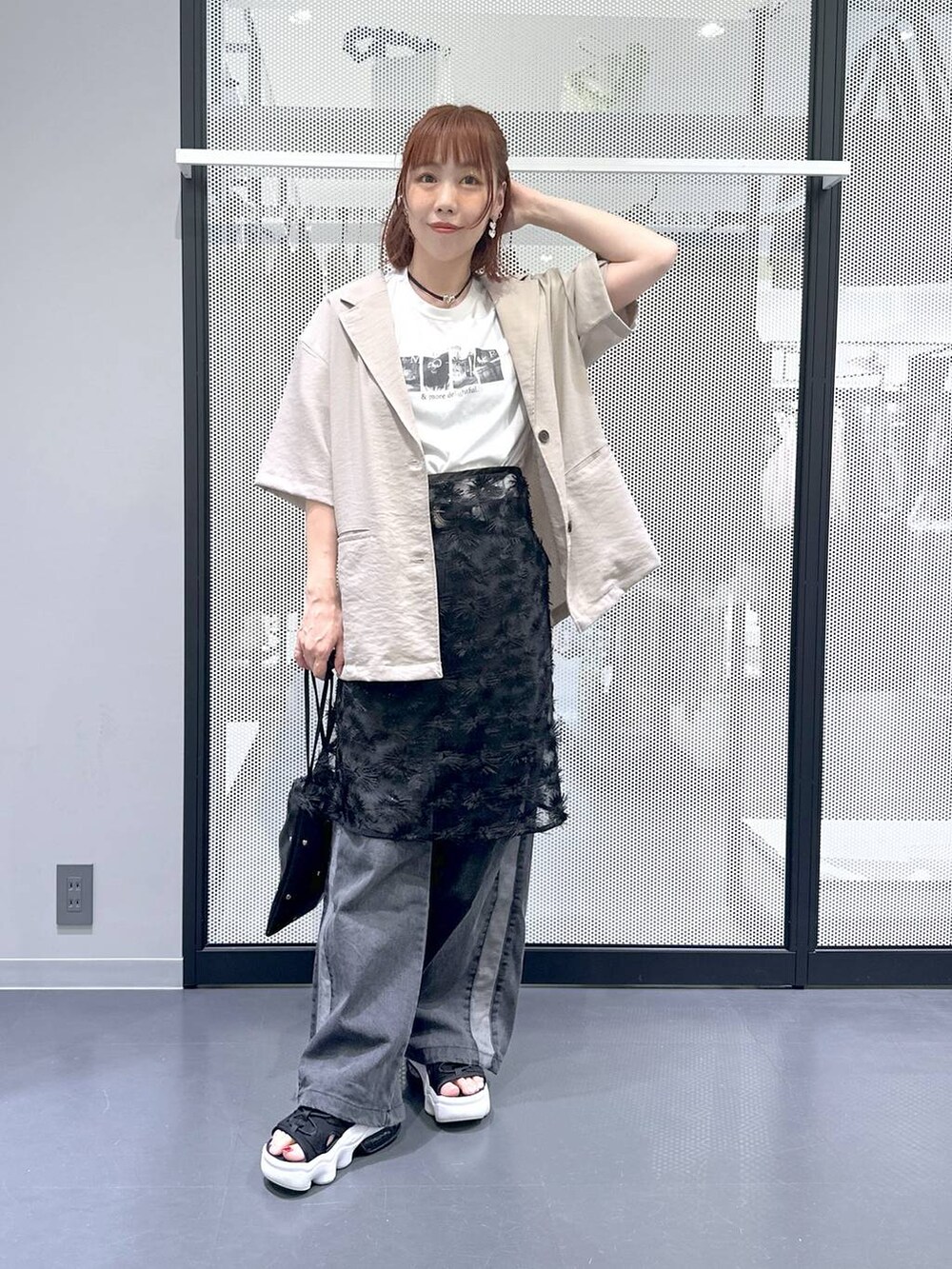 ブラック系のショルダーバッグ、ブラック系のデニムパンツ、ホワイト系のTシャツ/カットソーを着用したレディースの夏コーディネートの3枚目の写真