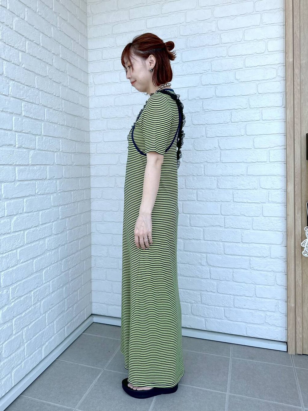 グリーン系のワンピース、ブラック系のサンダル、ブラック系のポーチを着用したレディースの春コーディネートの5枚目の写真