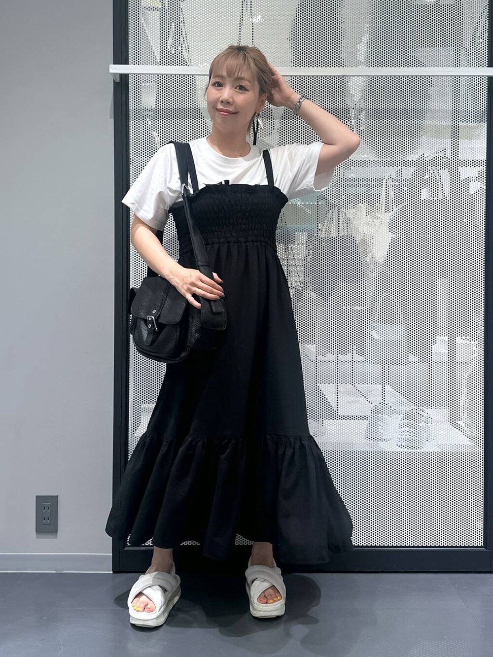 ブラック系のショルダーバッグ、ホワイト系のTシャツ/カットソー、ブラック系のワンピースを着用したレディースの夏コーディネートの2枚目の写真