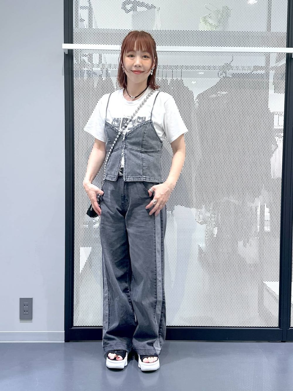 ブラック系のデニムパンツ、グレー系のベスト、ホワイト系のTシャツ/カットソーを着用したレディースの夏コーディネートの7枚目の写真