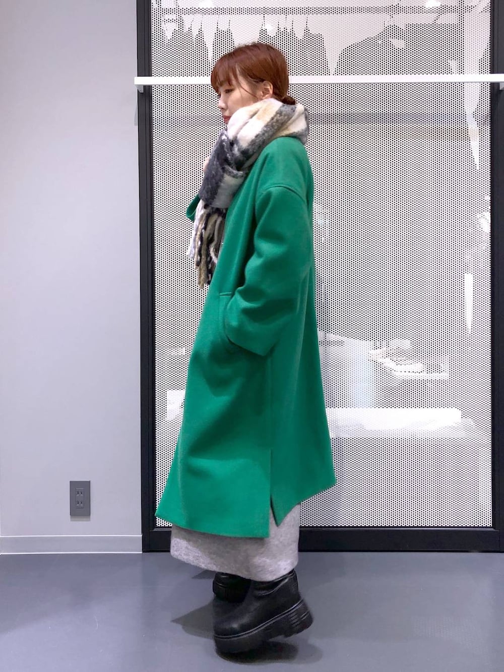 ブラック系のブーツ、シルバー系のショルダーバッグ、グリーン系のノーカラーコートを着用したレディースの冬コーディネートの3枚目の写真