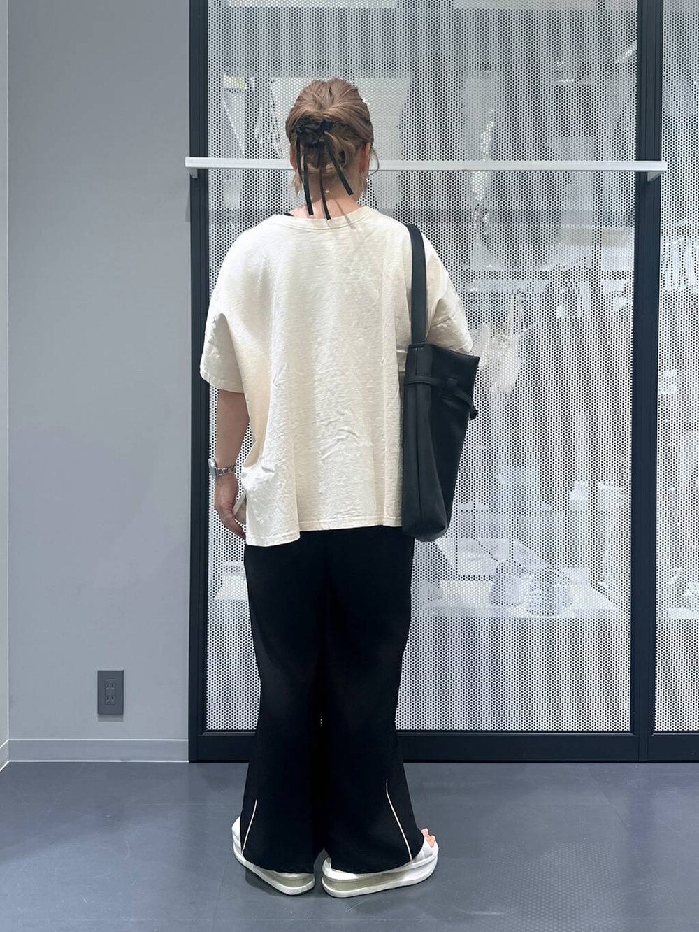 ブラック系のスラックス、ブラック系のショルダーバッグ、ブラック系のバレッタ/ヘアクリップを着用したレディースの夏コーディネートの3枚目の写真