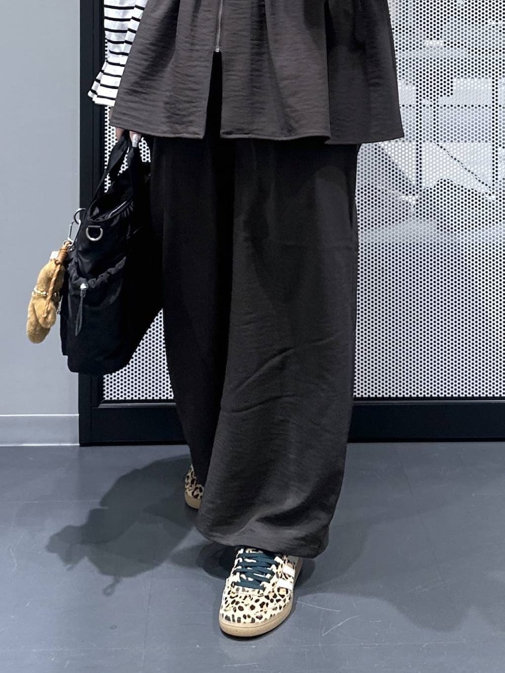 グレー系のその他パンツ、ブラック系のトートバッグ、ベージュ系のスニーカーを着用したレディースの春コーディネートの5枚目の写真