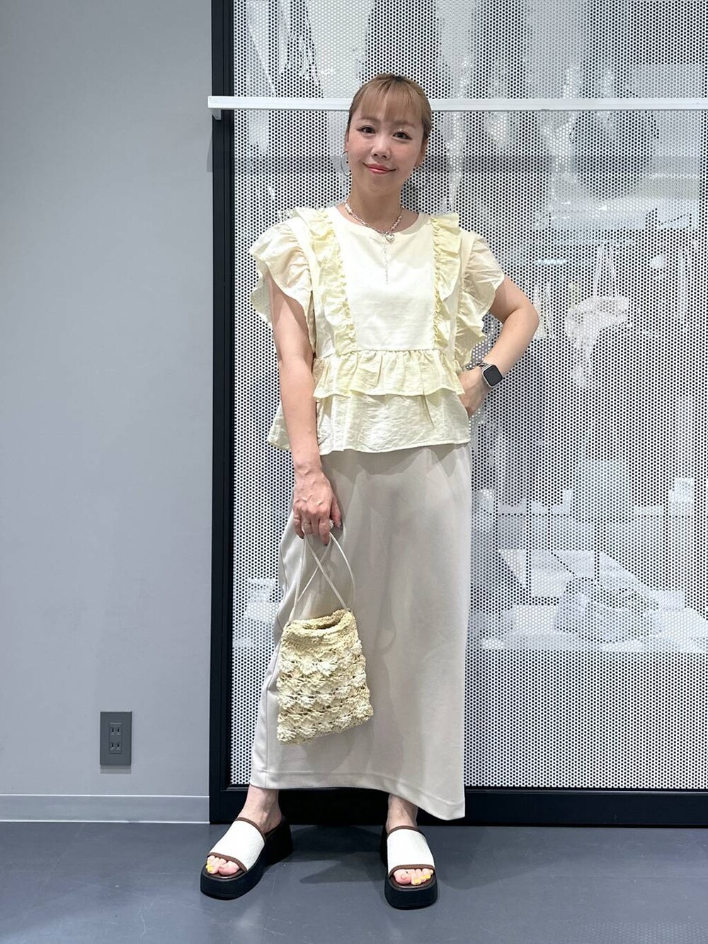 ホワイト系のサンダル、ベージュ系のショルダーバッグ、ベージュ系のスカートを着用したレディースの夏コーディネートの2枚目の写真