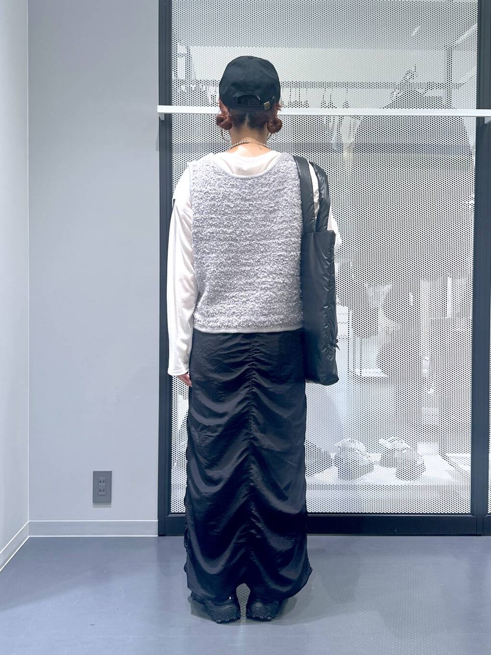 グレー系のスニーカー、ホワイト系のTシャツ/カットソー、グレー系のベストを着用したレディースの秋コーディネートの4枚目の写真