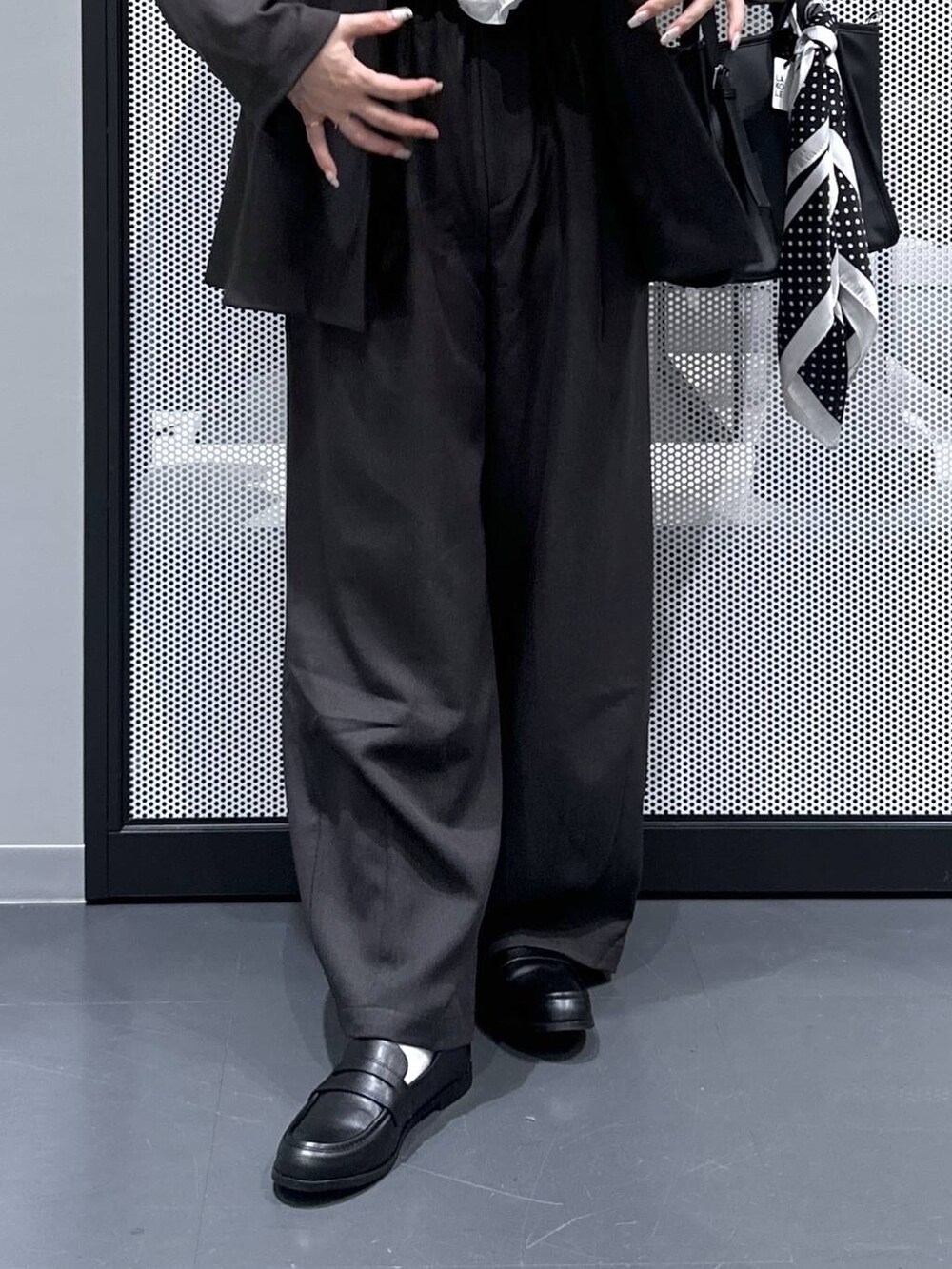 ブラック系のトートバッグ、グレー系のスラックス、ブラック系のローファーを着用したレディースの春コーディネートの5枚目の写真